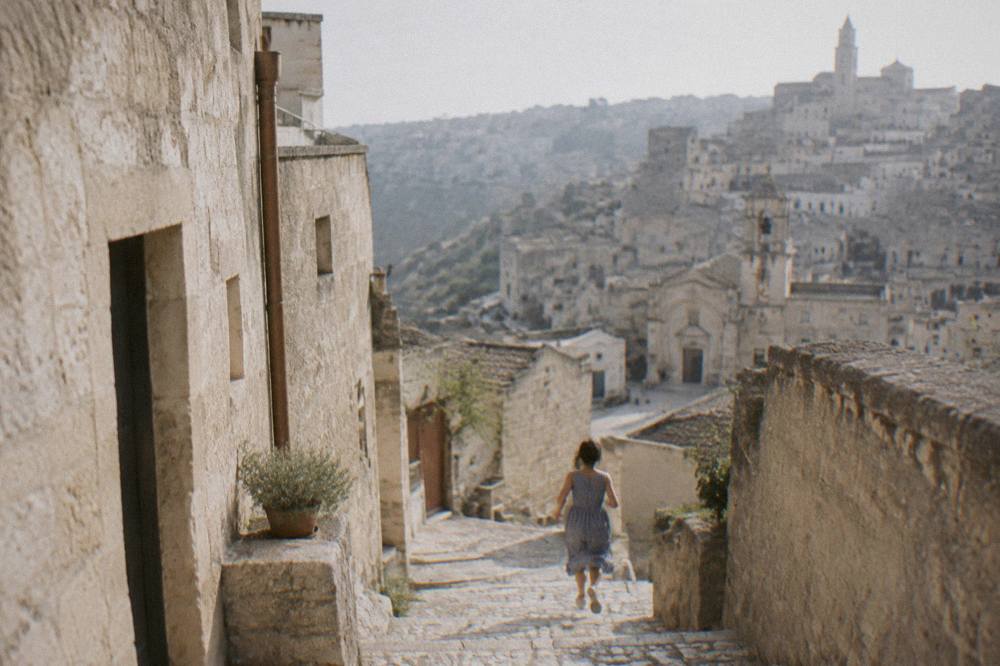 Narrow stepped lane between stone buildings in the Sassi of Matera on an overcast day