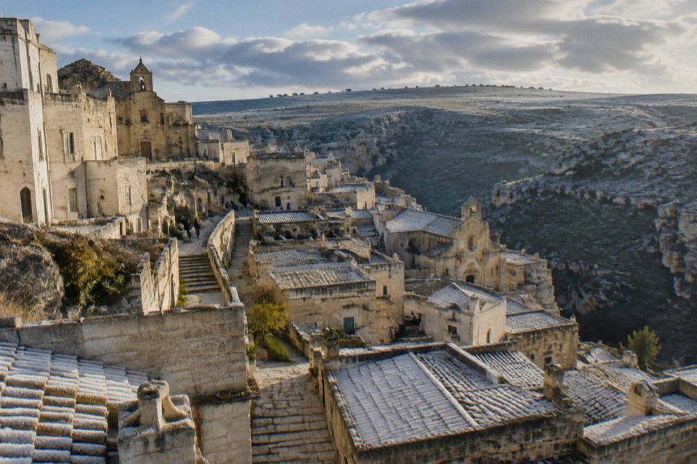 Frost on the stone rooftops of the Sassi at sunrise, with the Murgia plateau beyond
