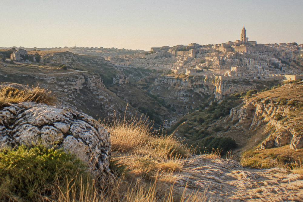 View across the Gravina canyon toward the Sassi cave districts from the Murgia side at golden hour