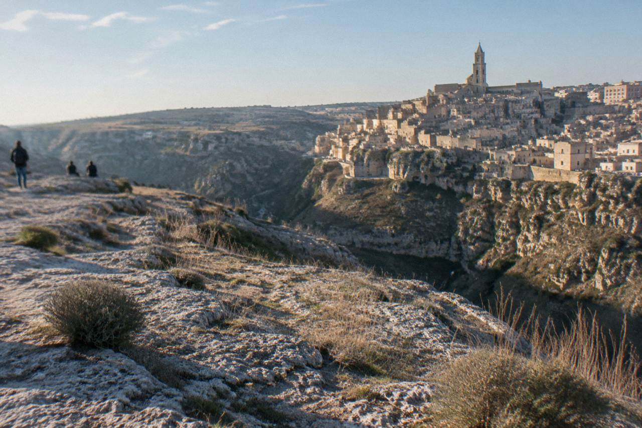Cave dwellings and stone houses of the Sassi districts rising above the Gravina canyon at dusk