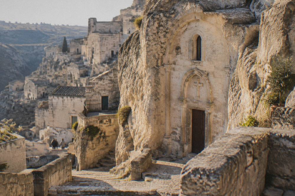 A rock-hewn church facade carved into pale limestone in the Sassi districts of Matera