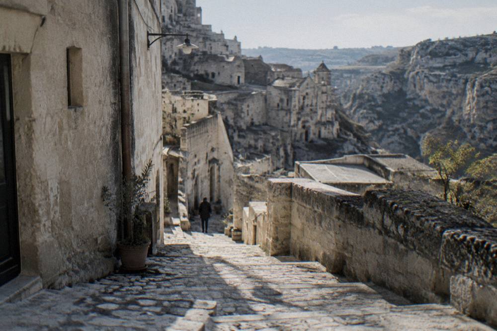 Narrow stepped lane between pale stone houses in the Sassi district of Matera