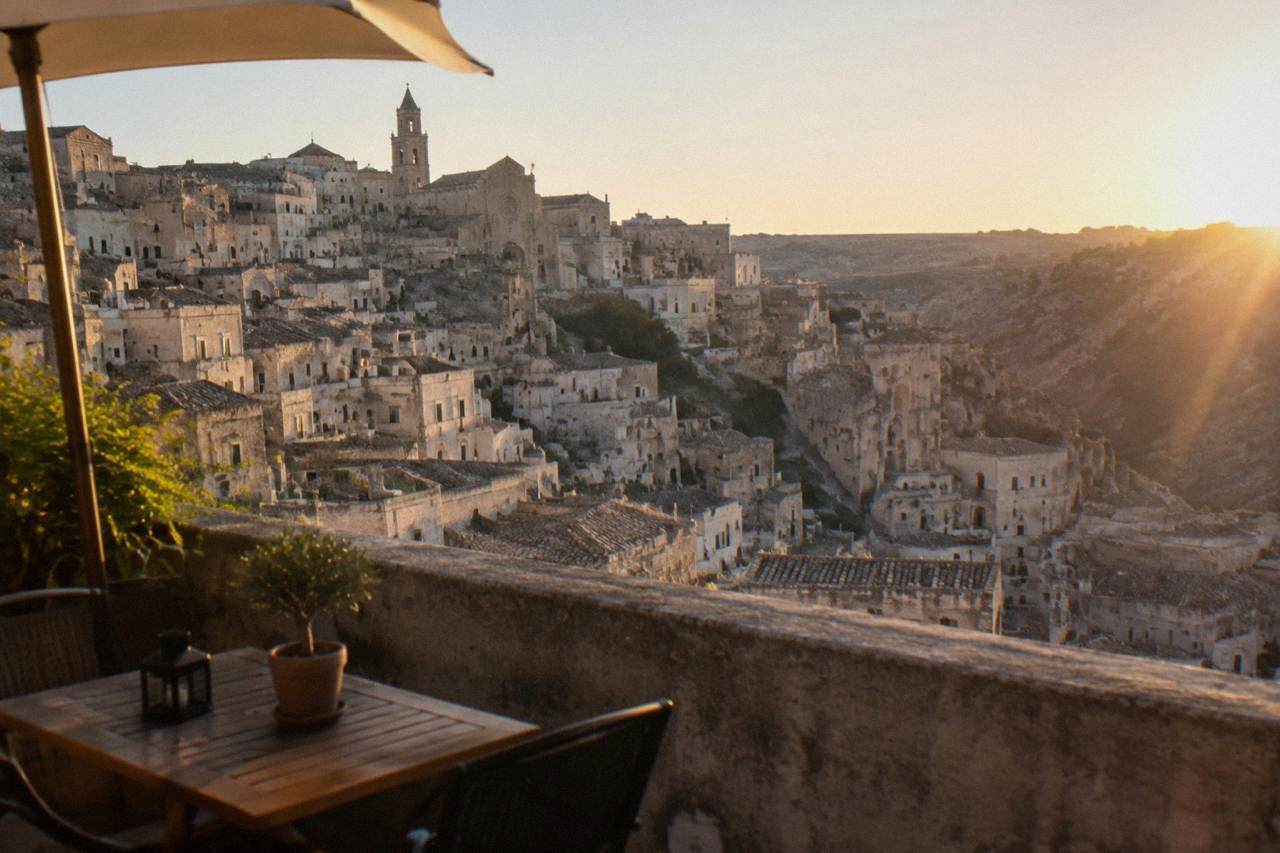 An evening terrace above the pale stone rooftops and cave dwellings of the Matera Sassi