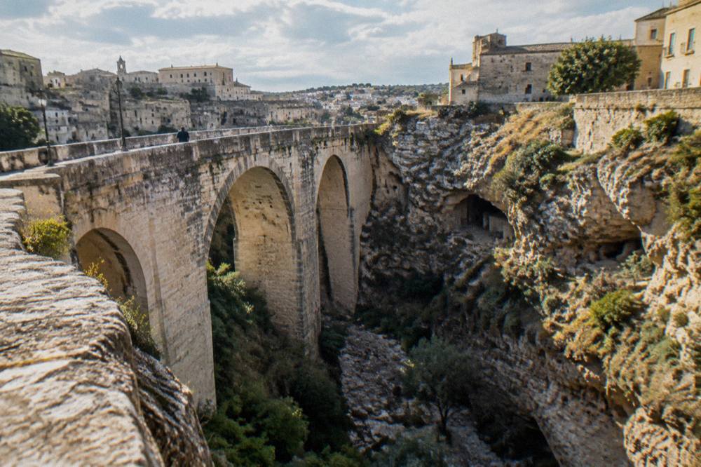 A stone bridge spanning a rocky canyon near Gravina in Puglia