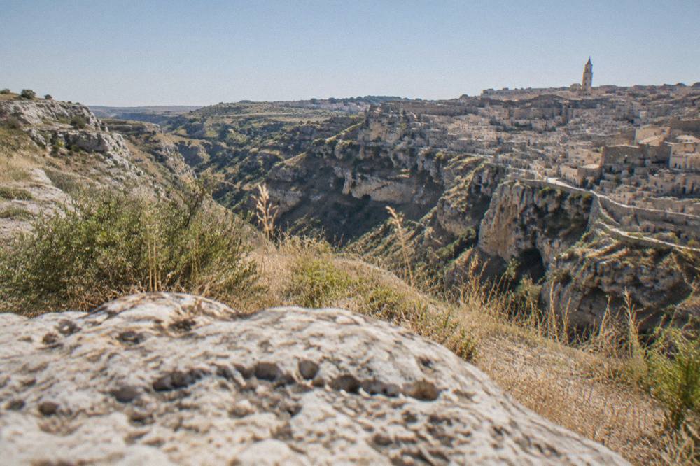 Restored cave houses and stone stairways in the Sassi districts of Matera seen across the Gravina canyon