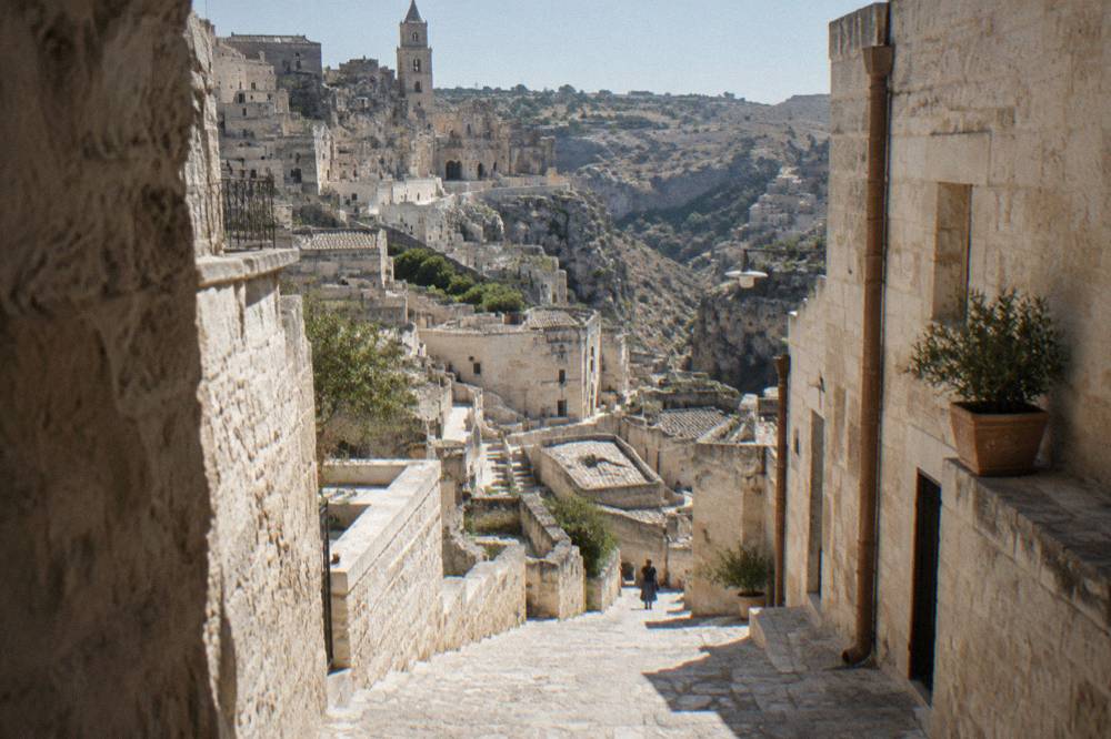 A narrow stepped lane in the historic center of Matera with pale stone walls