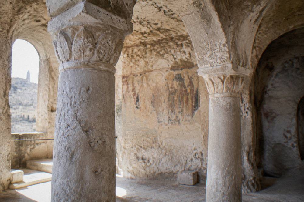 Interior of a rock-cut church with stone columns carved from the cave wall