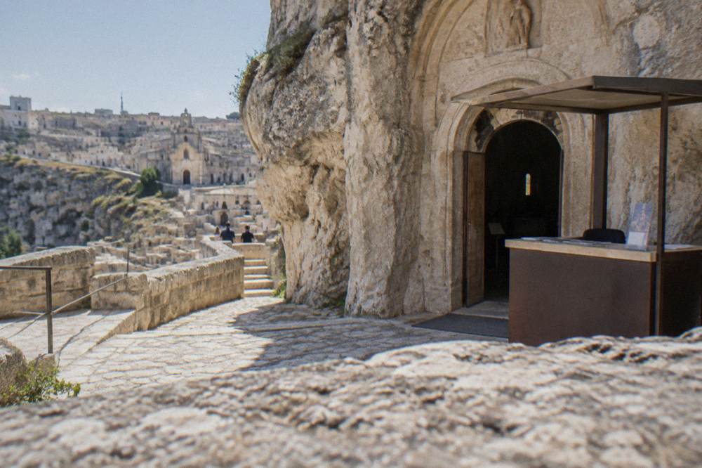Ticket desk and stone doorway of a rock church in Matera