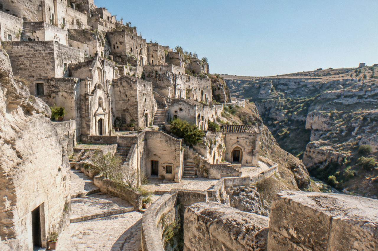 Pale stone cave dwellings stacked along the slope of Sasso Caveoso in Matera