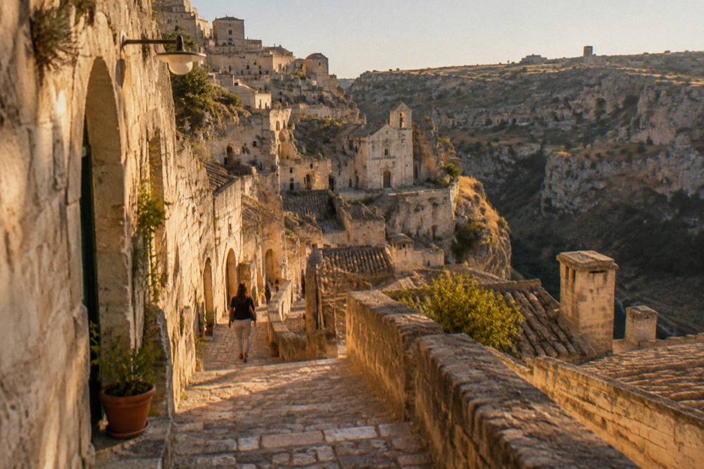 Narrow stepped lane of stone houses curving downhill inside Sasso Caveoso