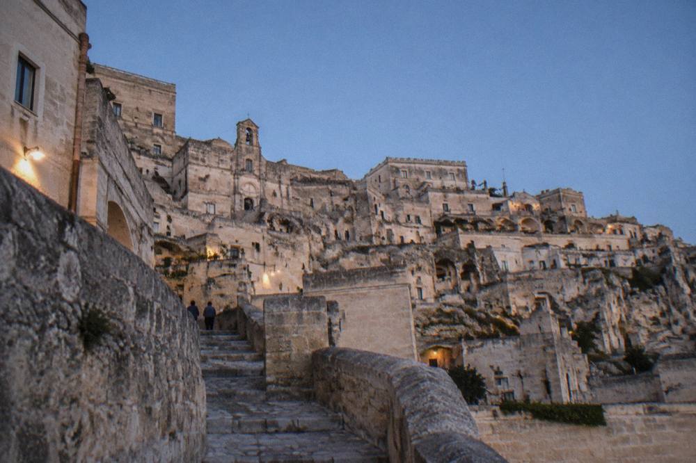 Pale tufa stone buildings of the Sassi terraced down a hillside under a clear sky