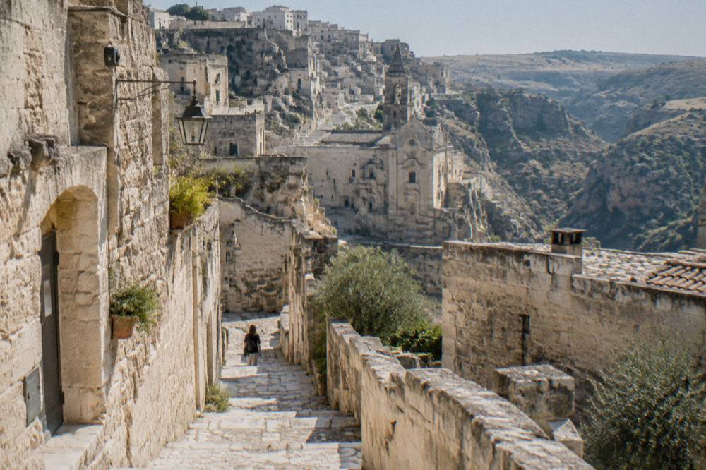 Stone steps and a narrow lane descending between cave house walls in the Sassi