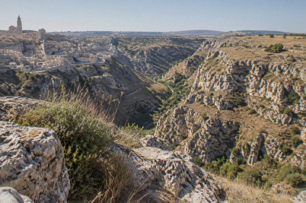 A view across the Gravina canyon from the Sasso Caveoso toward the Murgia plateau cliffs