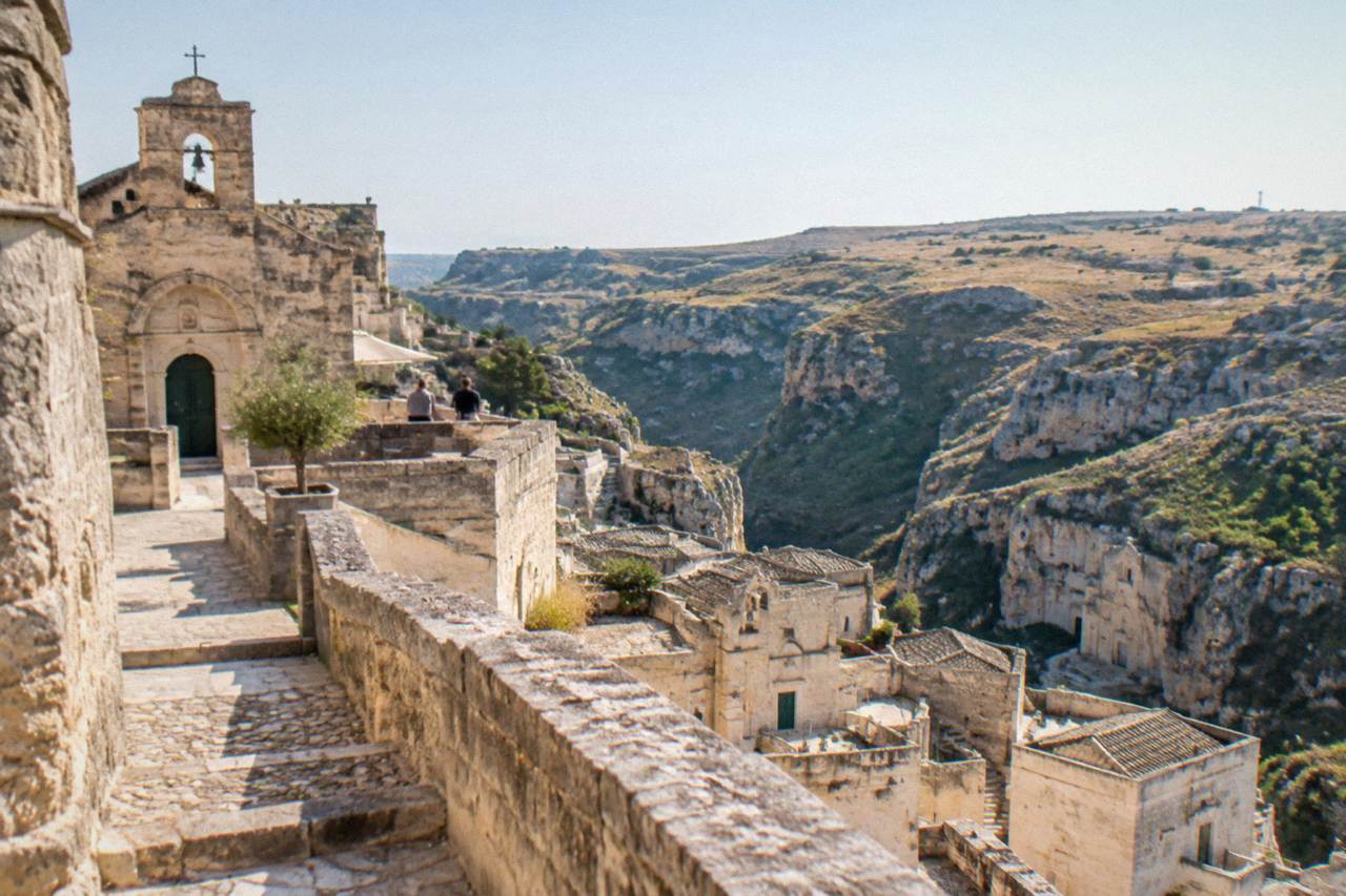 A stone church terrace in the Sassi of Matera looking across a canyon to a rocky plateau