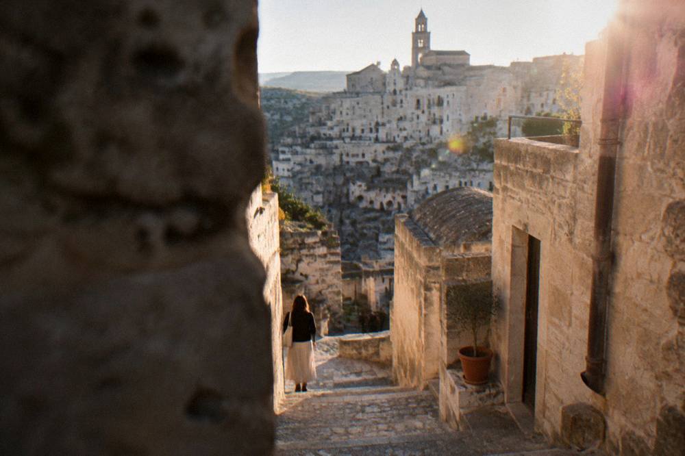 A narrow stone stairway between old cave buildings in the Sassi of Matera