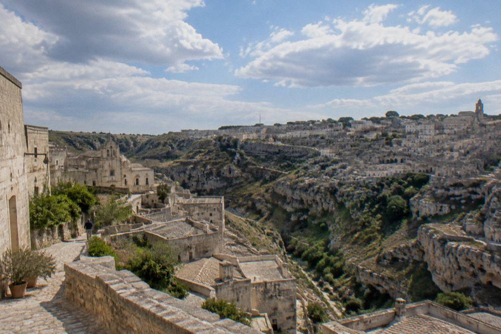 The canyon landscape of Matera seen from high ground with cave dwellings on the far slope