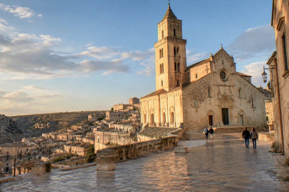 Matera Cathedral lit by warm evening light with the old city rooftops below