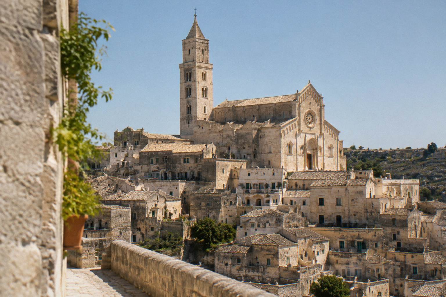 Romanesque cathedral tower and facade above the rooftops of the old town