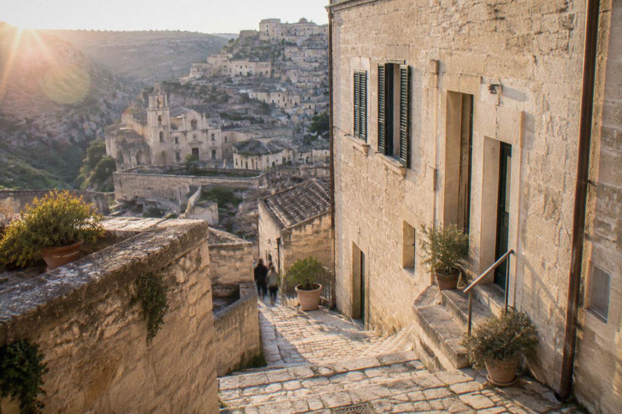 The stone facade of a museum building in Matera with shutters and a side entrance