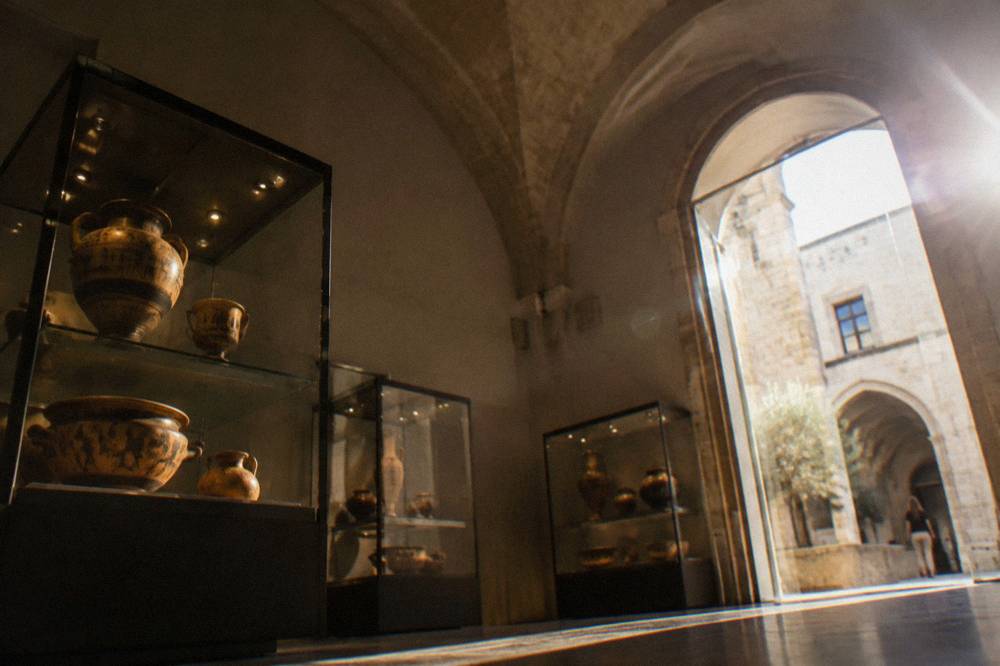 Display cases with ancient pottery in a dimly lit museum gallery