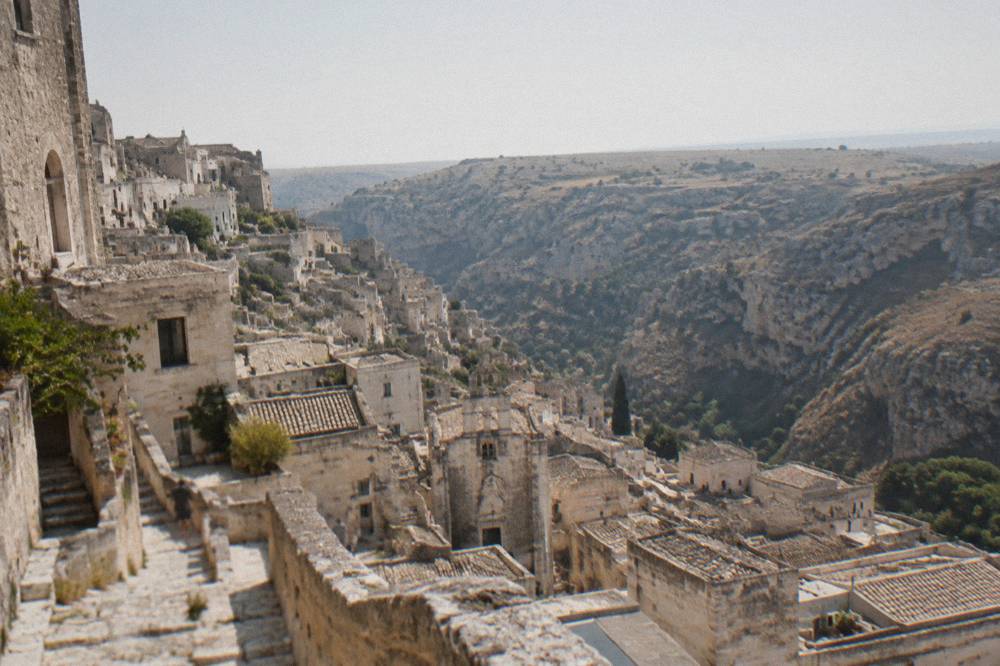 View over the Sasso Caveoso rooftops toward the Murgia plateau across the canyon