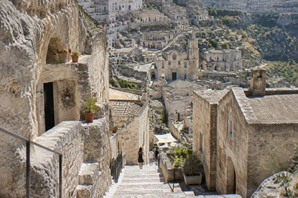 Stone stairway descending between cave houses in Matera at midday