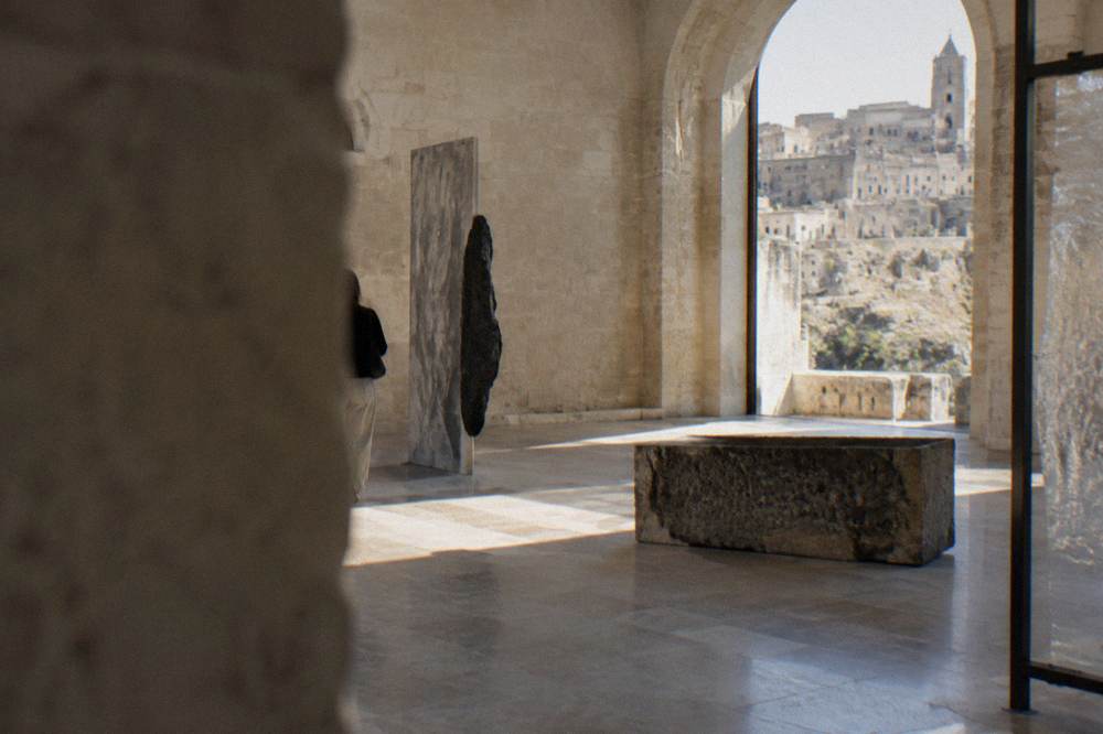 A contemporary art installation in a high stone hall of Palazzo Lanfranchi