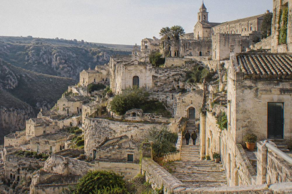 Worn stone steps between pale cave houses below the palace in Matera
