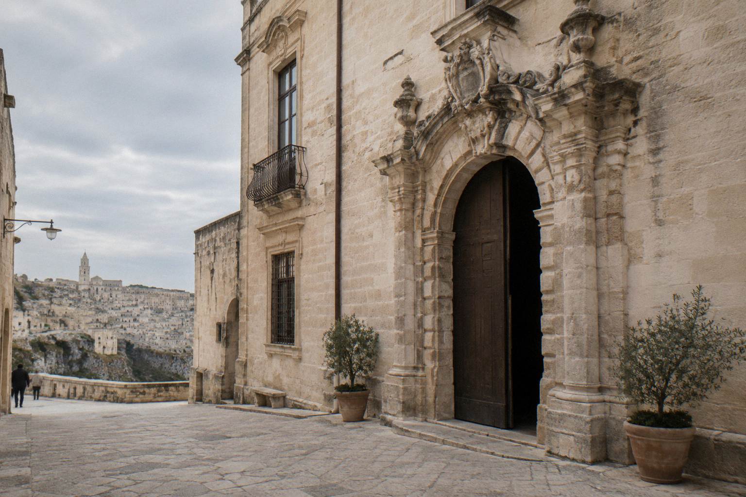 Baroque palace facade with a stone portal on a quiet street, overcast sky