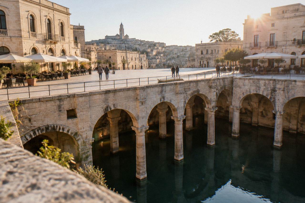 Vast stone cistern hall beneath Piazza Vittorio Veneto with arches and columns rising from still water