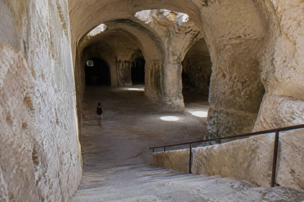 Stone staircase descending into the dim vaulted interior of an underground cistern