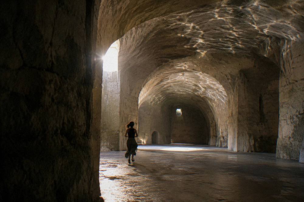 Water reflections on vaulted stone ceiling inside a dim underground cistern