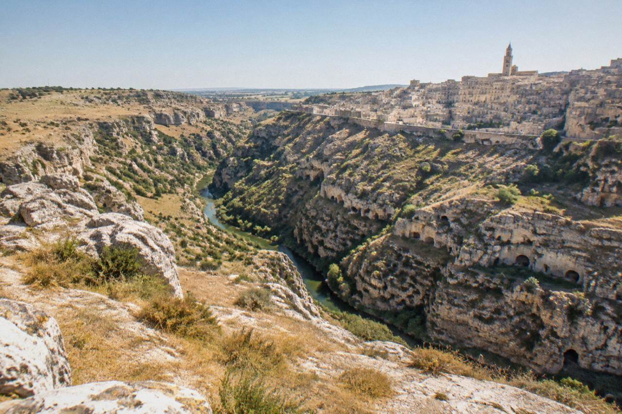 The Murgia plateau and rupestrian caves seen across the Gravina canyon from Matera
