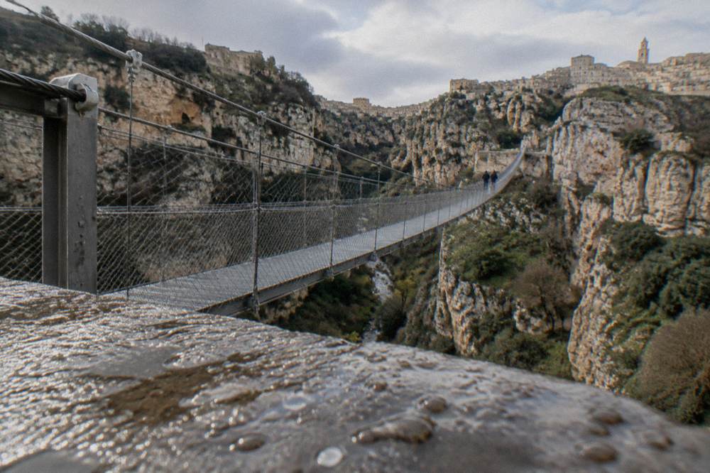 A wire suspension footbridge spanning a deep limestone canyon