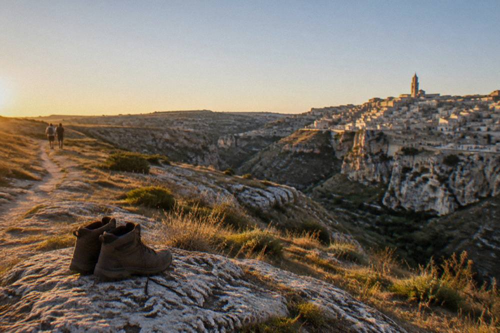 Walking boots resting on limestone rock beside a marked path on the plateau