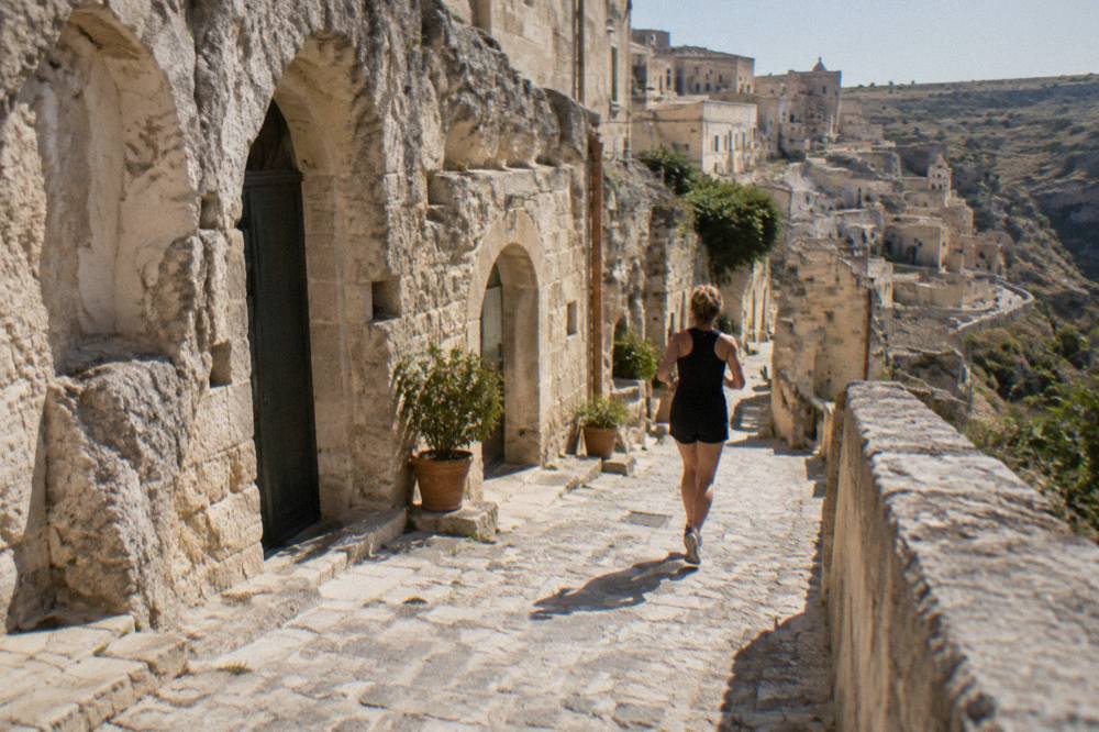 Narrow stone lane in Sasso Barisano with cave doorways cut into the rock wall