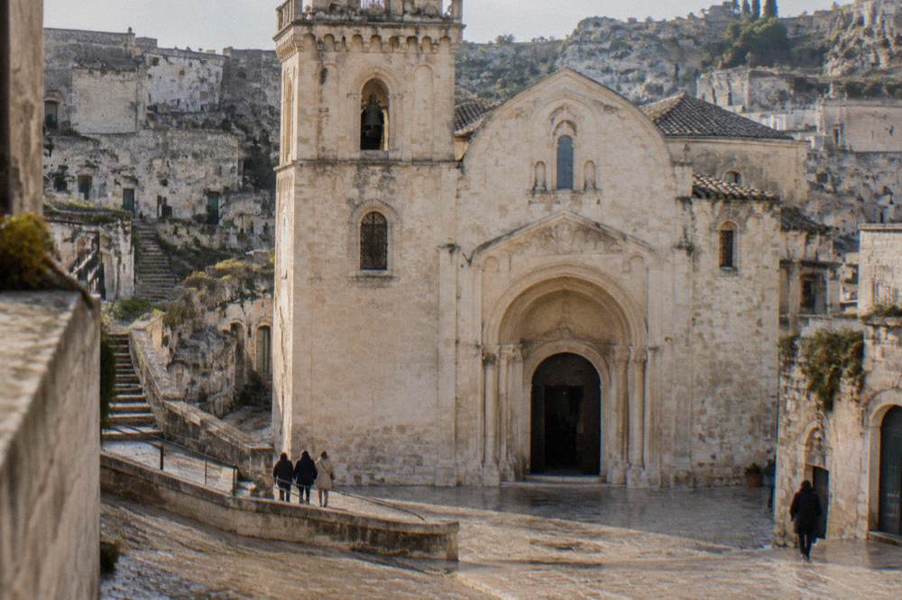 Tall carved archway leading into a dim rock-cut church interior