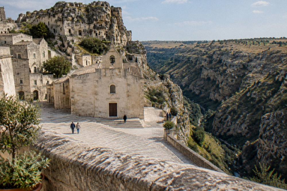 The stone parapet of a square overlooking a deep canyon with a plateau beyond