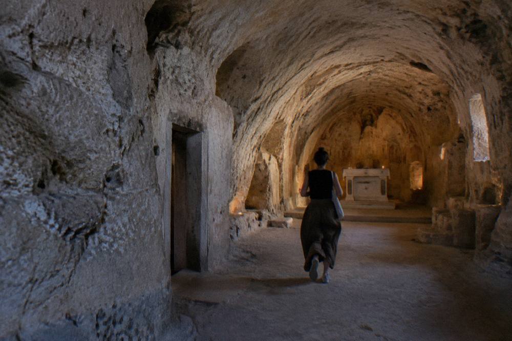 Interior of a cave church with a vaulted ceiling rough-hewn from pale rock