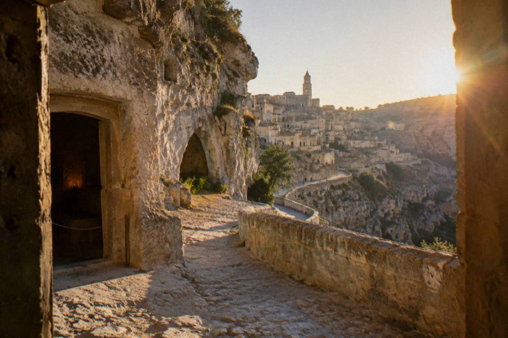 Terraced cave dwellings stacked along the canyon wall at golden hour