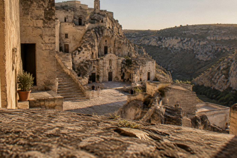 Small square with cave facades and stone stairways in the Sasso Caveoso