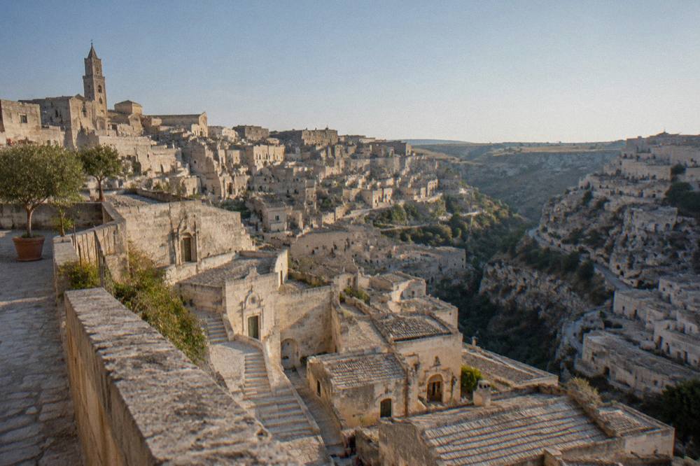 The steep cave city of Matera seen from a high terrace under a clear afternoon sky
