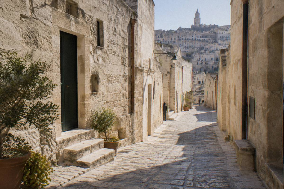 A narrow stone lane between pale limestone houses in Sasso Barisano, empty in morning light