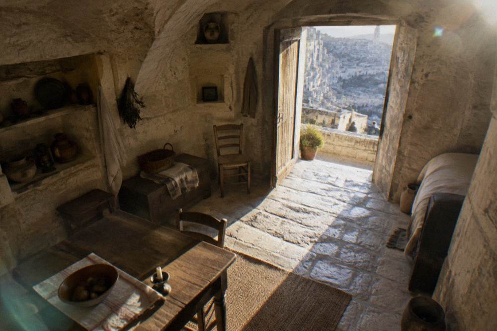 A furnished cave house interior with stone walls and period household tools