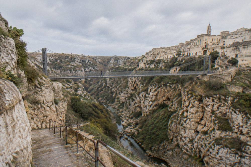 A stone stairway descending a canyon wall with handrails, cut into pale rock