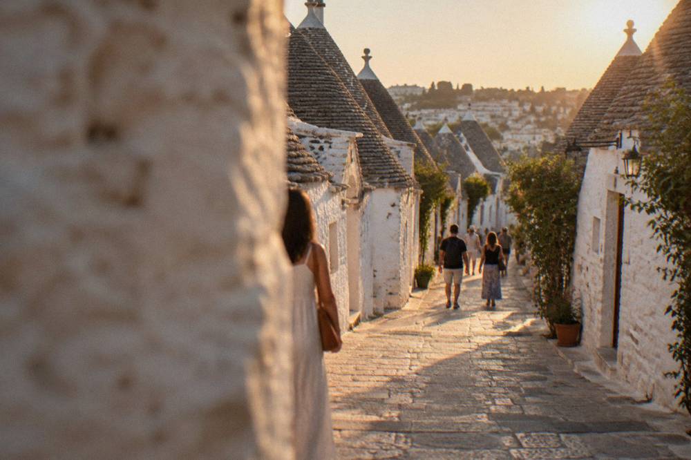 A narrow lane in Alberobello lined with small trulli houses and stone paving