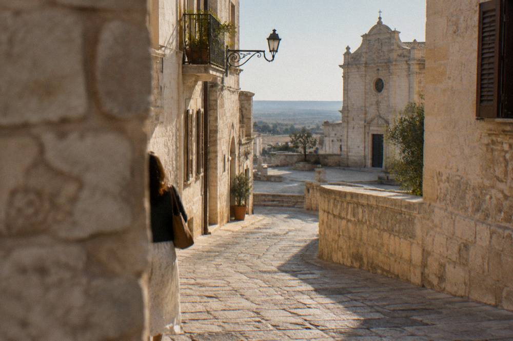 A narrow stone lane curving between old buildings in a southern Italian town