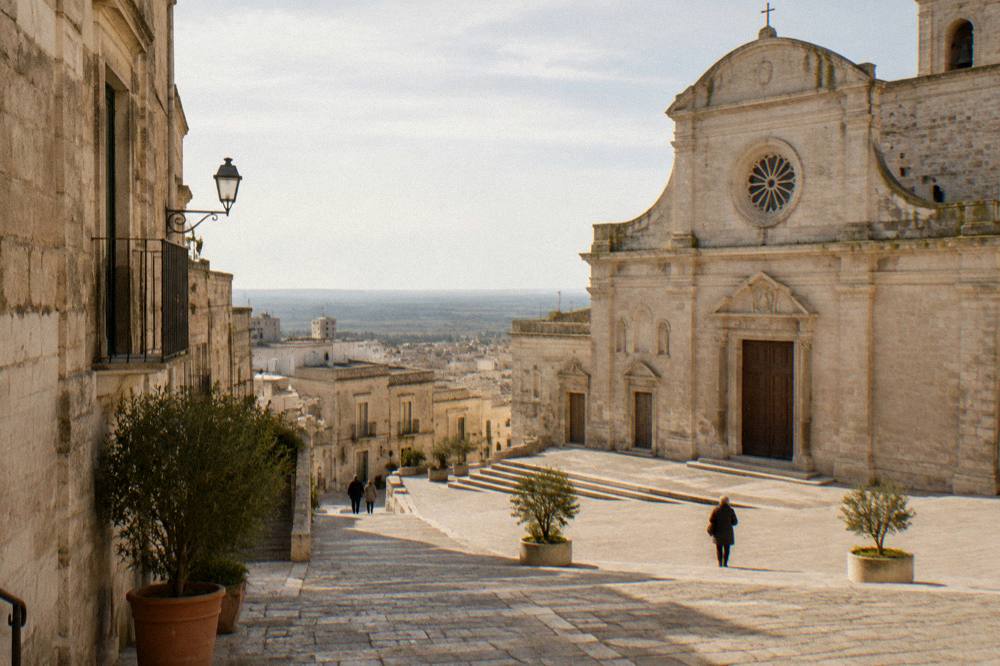 An old stone square in warm late afternoon light in a southern Italian town