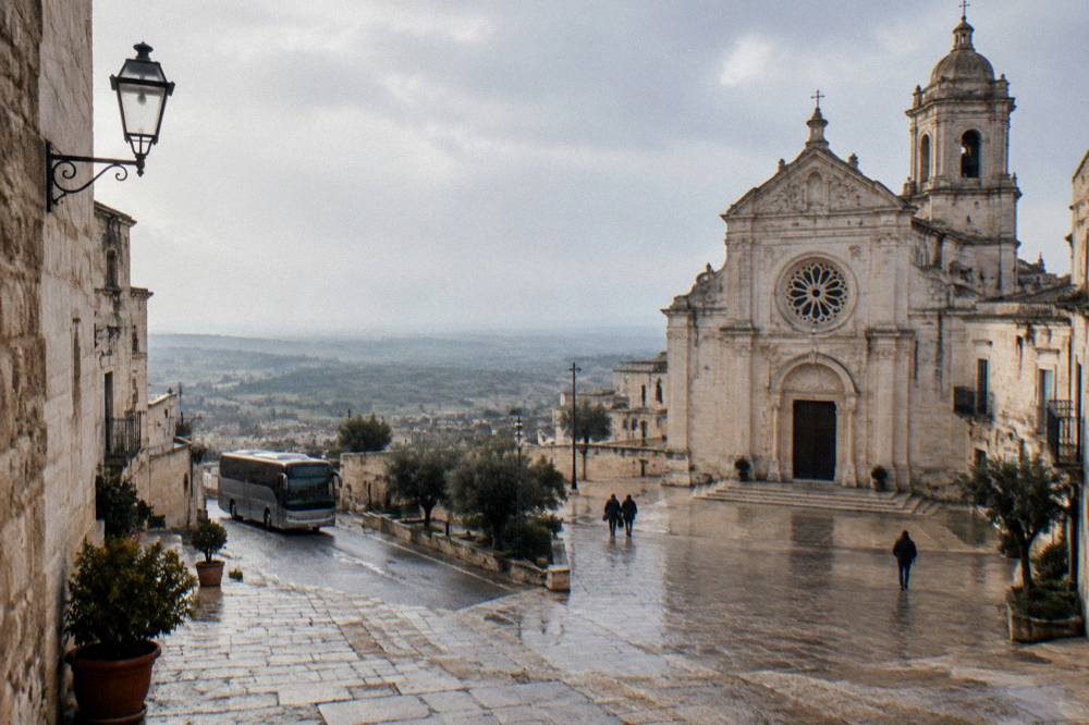 A coach parked on a country road between stone towns in southern Italy