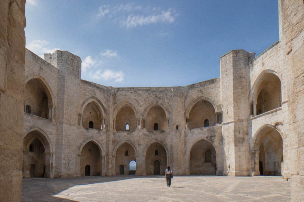 The interior courtyard of an octagonal stone castle with symmetrical arches